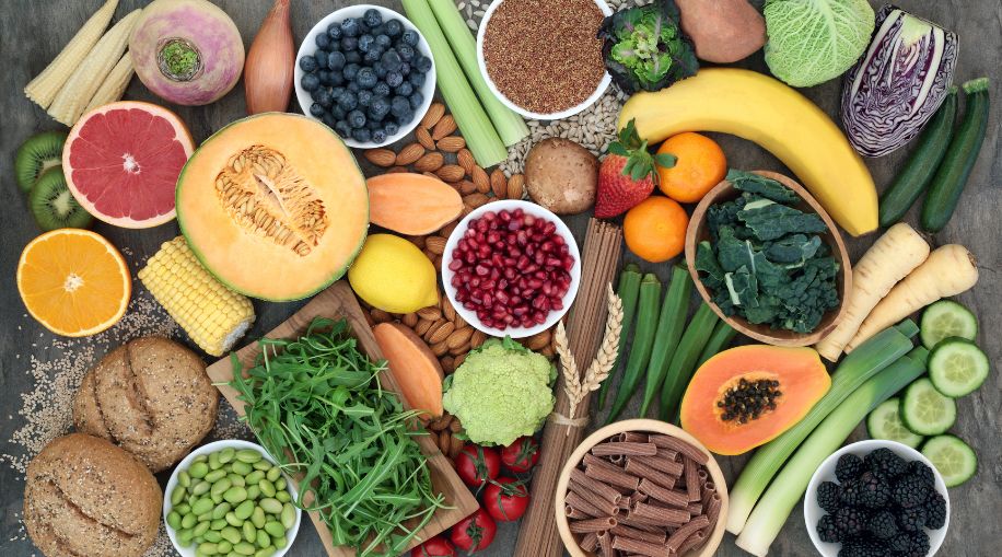 An assortment of healthy foods: fruit, vegetables, whole wheat bread.