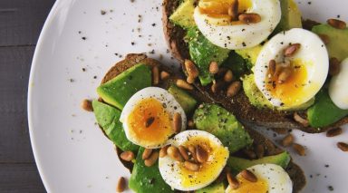 Toast topped with avocado and hard boiled eggs.
